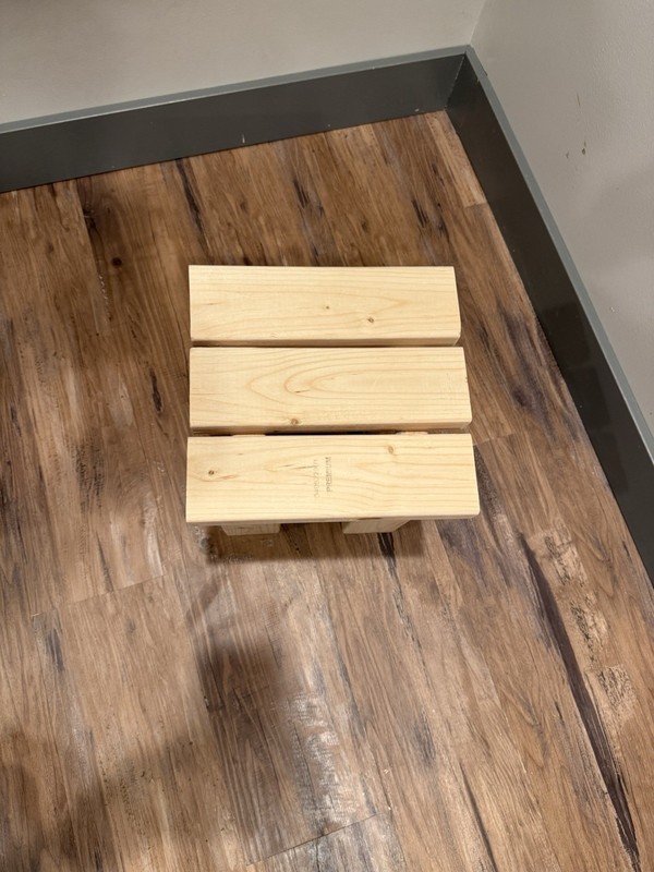 Handmade wooden table with a rustic design, sturdy legs, and solid build.